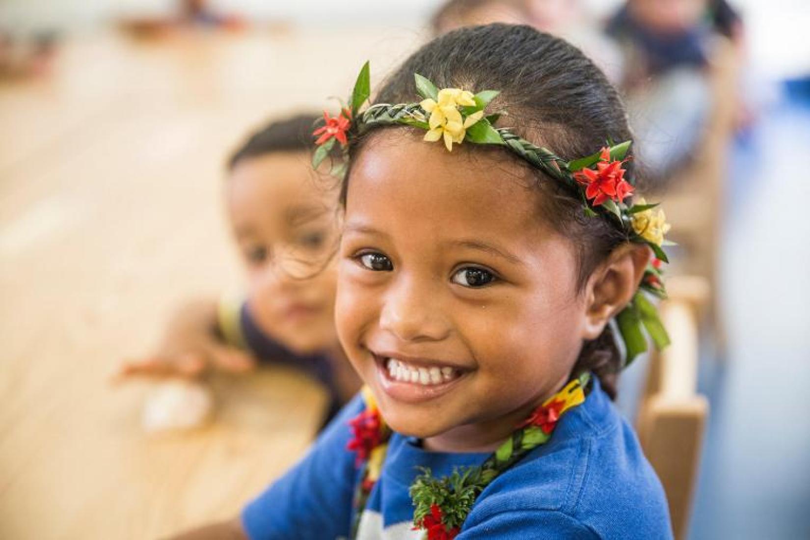 A young Tongan girl smiles at the camera