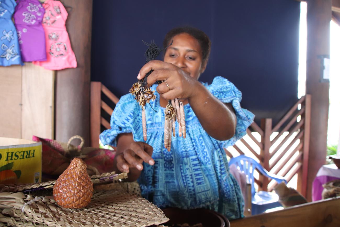 A market vendor in Vanuatu displays necklaces to tourists in Port Vila. 