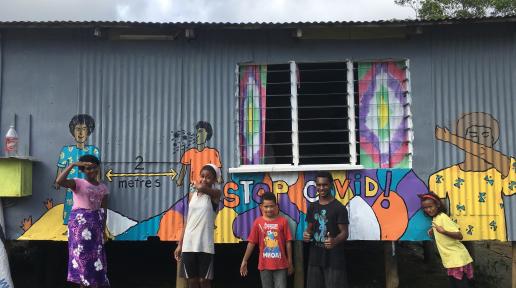 Youth and a COVID-19 awareness mural in Vuniivi settlement Lami, Fiji